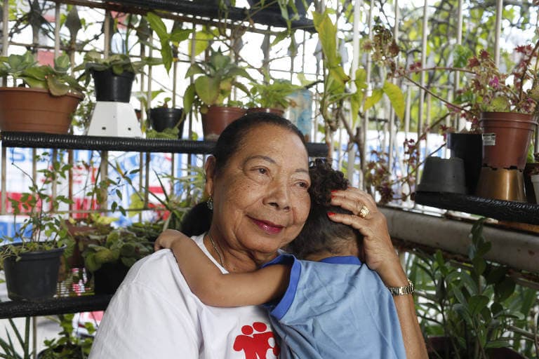 Woman embracing a child in an environment with plants